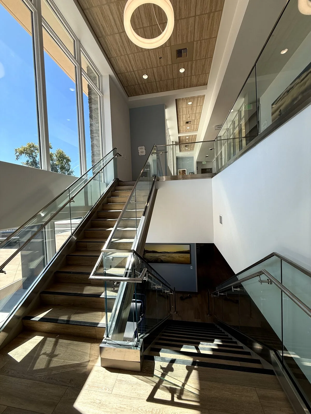 Switchback stair landing with continuous glass railing and stainless handrails