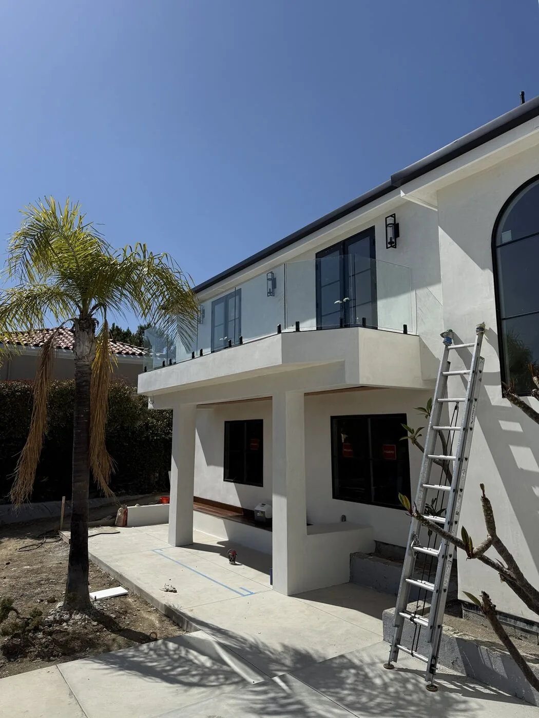 Frameless glass balcony railing we installed on a modern white two-story California home